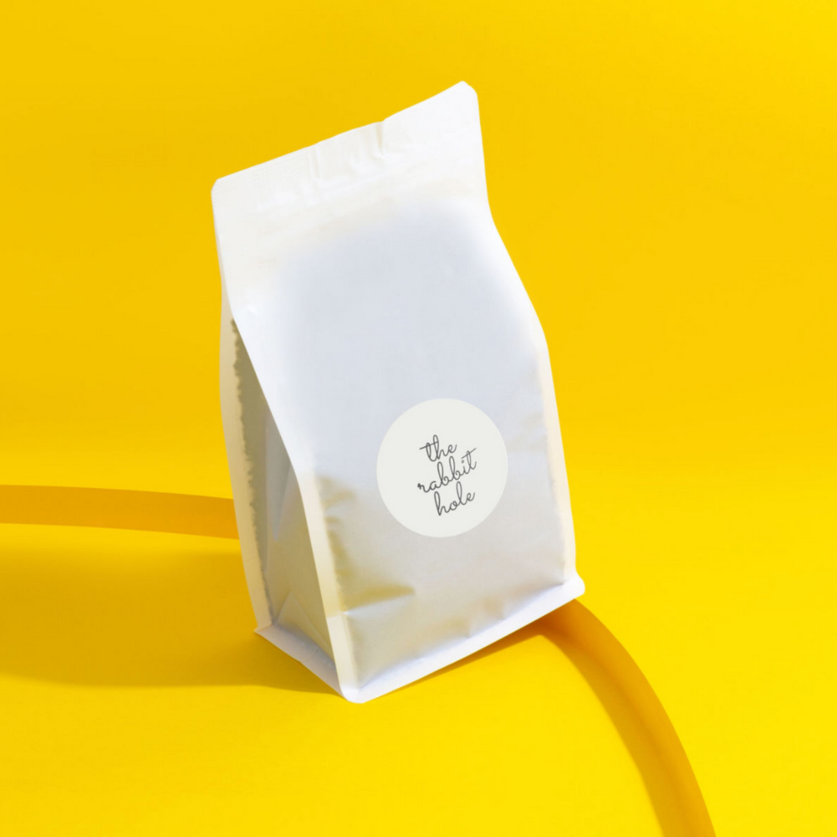 Bulk bag of loose leaf tea by The Rabbit Hole - Australian Made Tea on colourful yellow background.