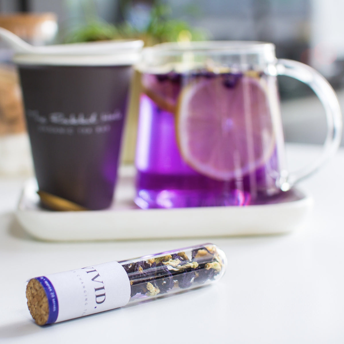 Vivid loose leaf tea by The Rabbit Hole - purple tea in teapot with cup and tube of Vivid tea 